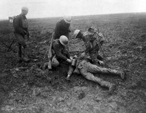 Soldiers tending wounded comrade in muddy battlefield